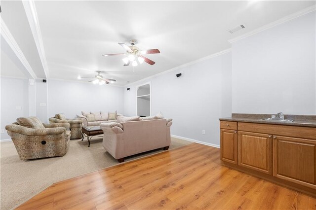 living room with ornamental molding, sink, ceiling fan, and light hardwood / wood-style floors