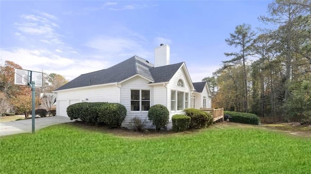 view of property exterior featuring a garage, a wooden deck, and a lawn