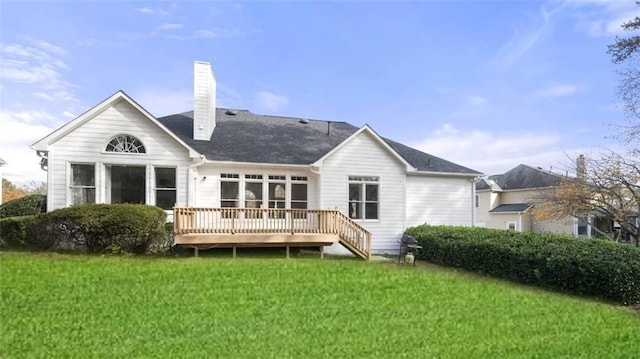 rear view of property with a deck and a lawn