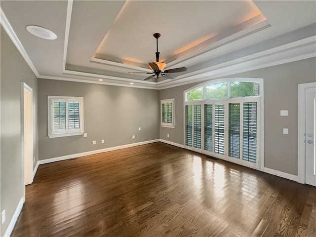 unfurnished room with ornamental molding, a tray ceiling, ceiling fan, and dark hardwood / wood-style flooring