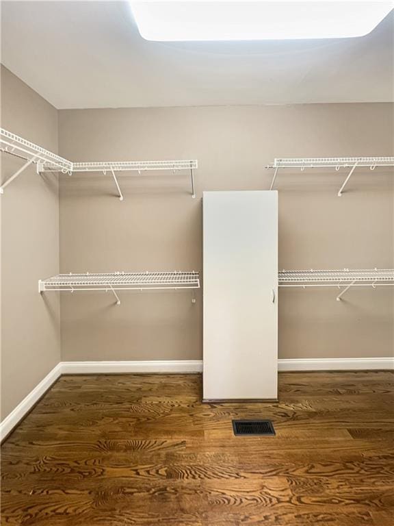 spacious closet with dark hardwood / wood-style floors