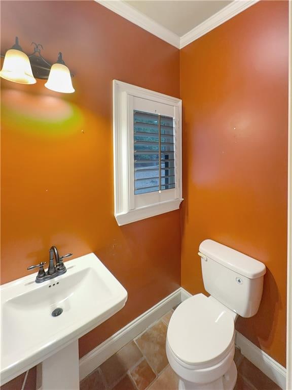 bathroom with ornamental molding, sink, and toilet