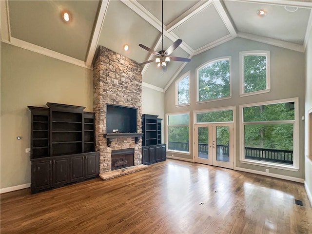 unfurnished living room featuring ceiling fan, wood-type flooring, high vaulted ceiling, a fireplace, and crown molding