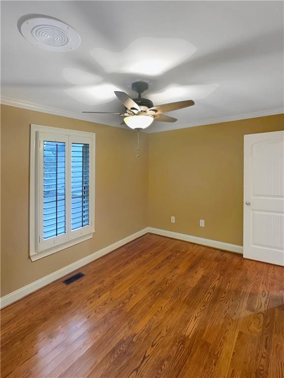 spare room featuring ceiling fan, hardwood / wood-style flooring, and crown molding