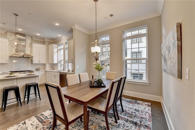 dining space with hardwood / wood-style flooring, plenty of natural light, and sink