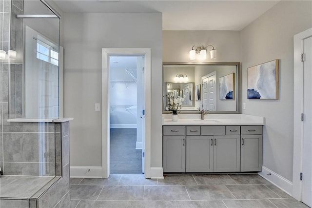 bathroom featuring tile patterned flooring, vanity, and a shower