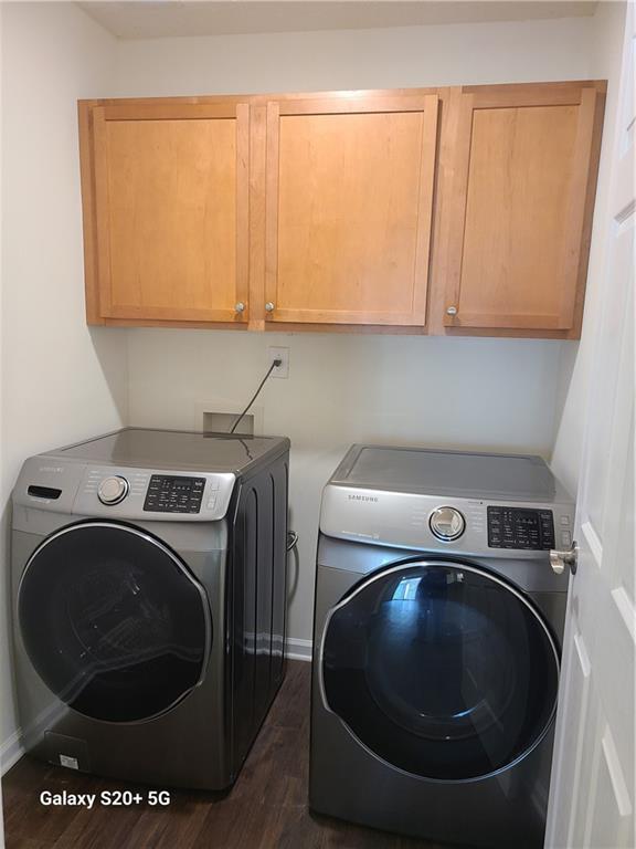 303 Tara Commons Cir, Loganville, GA 30052 - washroom with cabinet space, separate washer and dryer, and dark wood-type flooring