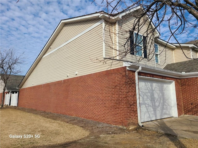 303 Tara Commons Cir, Loganville, GA 30052 - view of side of property with an attached garage, brick siding, and driveway