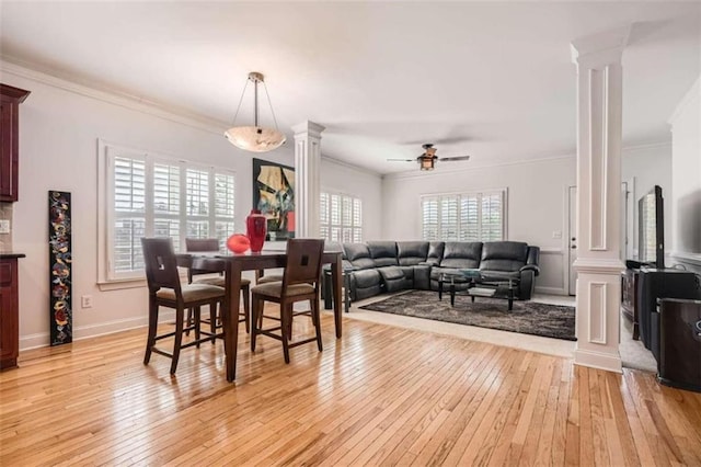 dining space with light hardwood / wood-style floors, crown molding, ceiling fan, and decorative columns