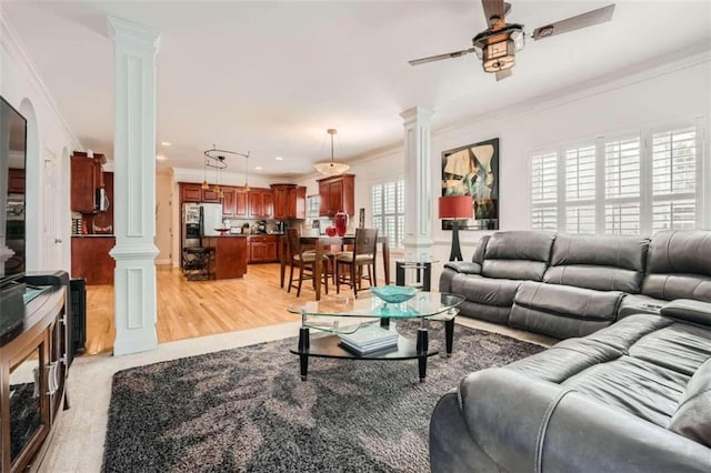 living room featuring ornamental molding, light hardwood / wood-style flooring, a healthy amount of sunlight, and ceiling fan