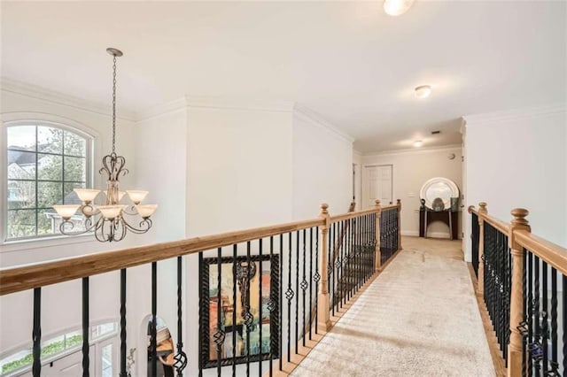 hall featuring ornamental molding and a chandelier