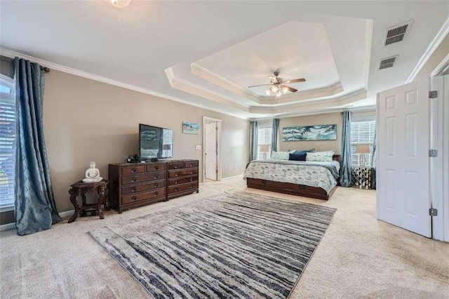 bedroom featuring ceiling fan, crown molding, a raised ceiling, and light colored carpet