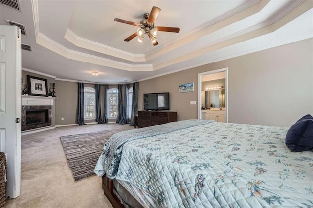 bedroom with ceiling fan, ornamental molding, a tray ceiling, and light colored carpet