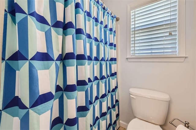 bathroom with toilet and curtained shower