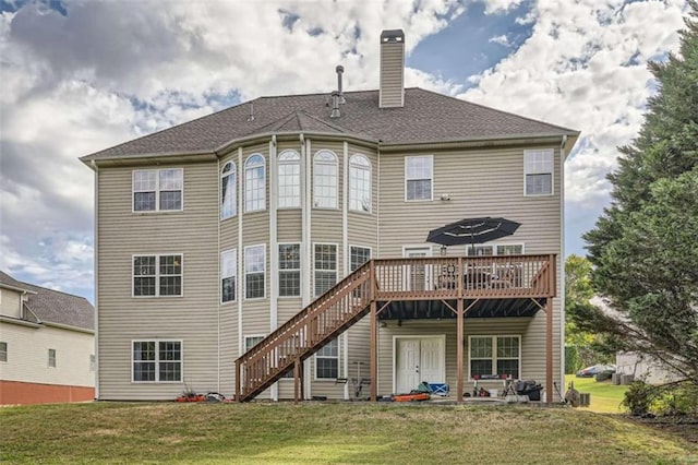 rear view of property featuring a yard, a patio, and a wooden deck