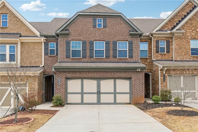 view of property featuring a garage, brick siding, and concrete driveway