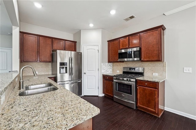 kitchen featuring a sink, stainless steel appliances, light stone countertops, and visible vents