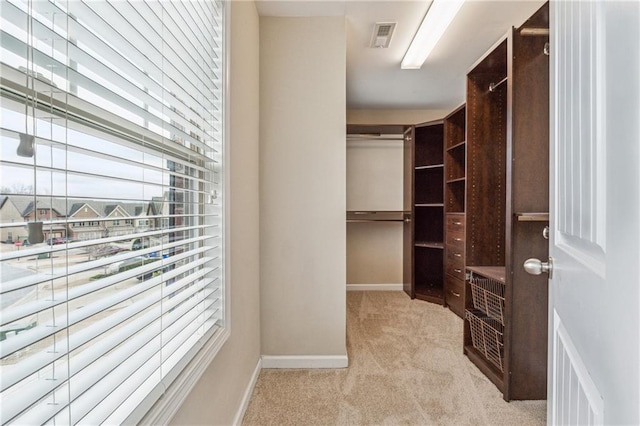 walk in closet featuring visible vents and light colored carpet