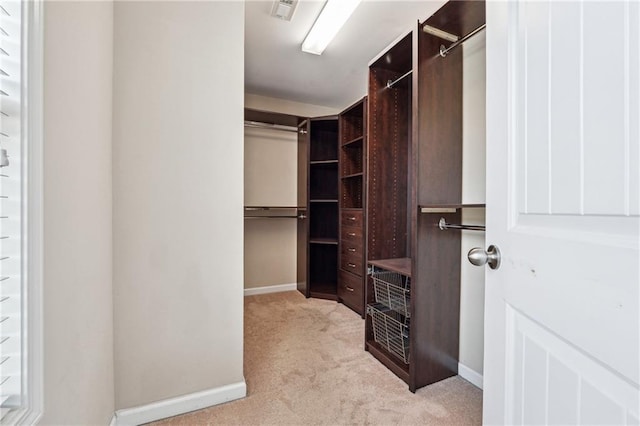 walk in closet with visible vents and light colored carpet