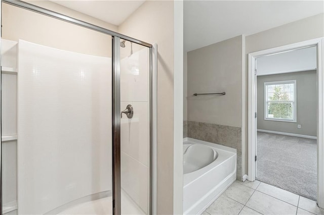 bathroom featuring tile patterned flooring, a shower stall, baseboards, and a garden tub