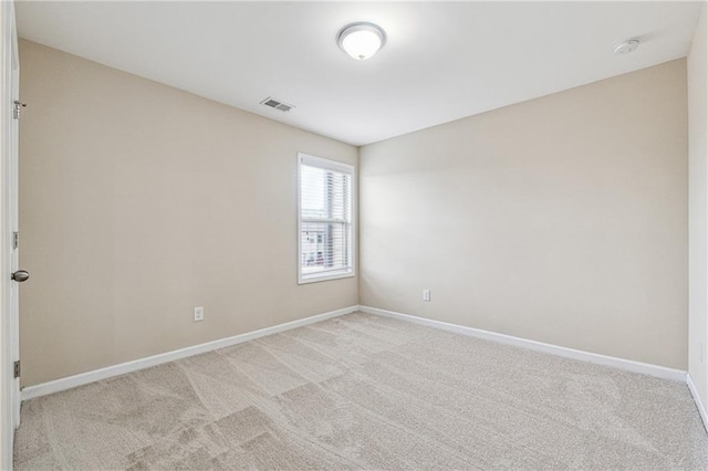 empty room with visible vents, light colored carpet, and baseboards