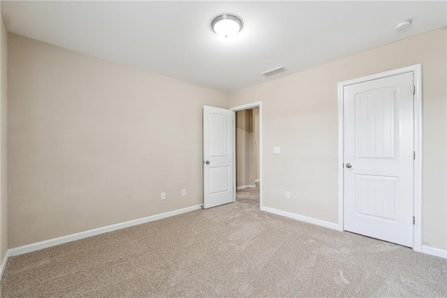 unfurnished bedroom featuring visible vents, baseboards, and carpet