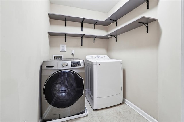 clothes washing area with laundry area, baseboards, and independent washer and dryer