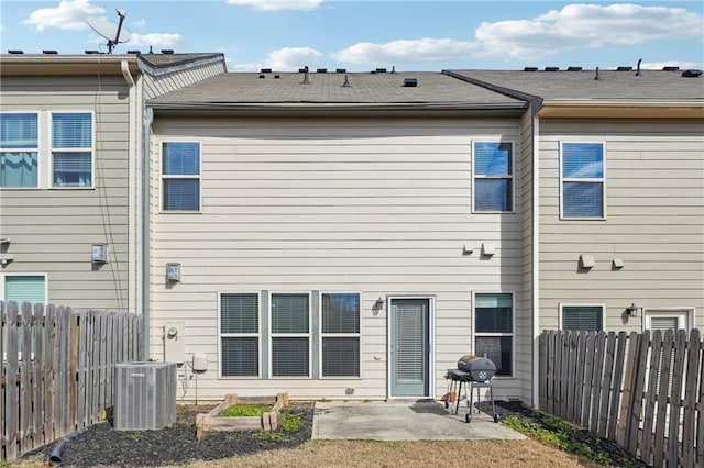 rear view of house with a patio area, central AC unit, and fence