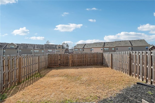 view of yard featuring a residential view and a fenced backyard