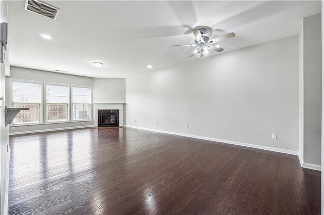 unfurnished living room with dark wood finished floors, visible vents, and baseboards