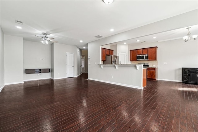 unfurnished living room featuring visible vents, ceiling fan with notable chandelier, dark wood finished floors, recessed lighting, and baseboards