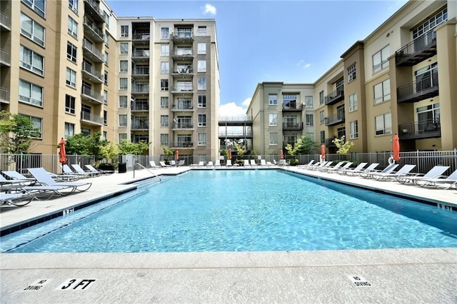 community pool with a patio and fence