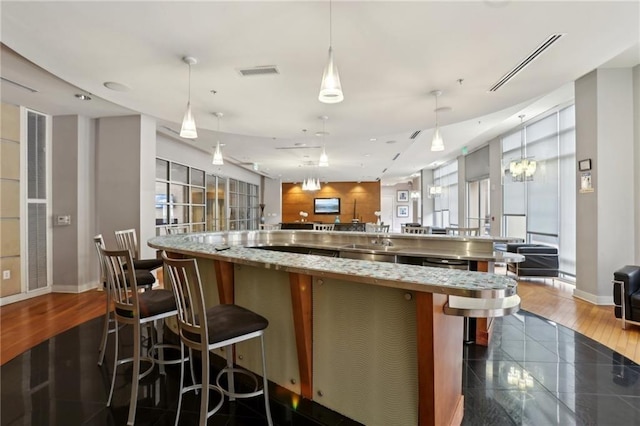 kitchen featuring baseboards, visible vents, a large island, and open floor plan