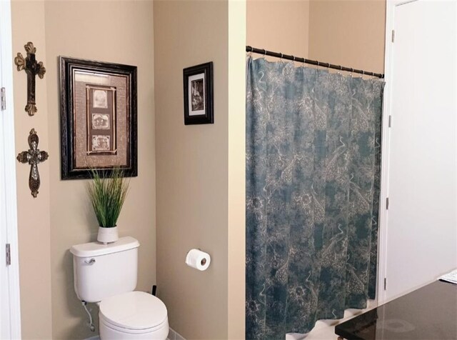 711 Cosmopolitan Dr NE Unit 123, Atlanta, GA 30324 - bathroom featuring toilet, baseboards, and a shower with shower curtain
