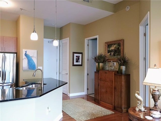 kitchen with pendant lighting, a sink, visible vents, freestanding refrigerator, and dark wood-style flooring