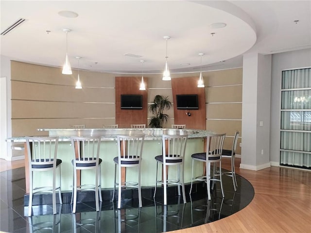 711 Cosmopolitan Dr NE Unit 123, Atlanta, GA 30324 - kitchen featuring pendant lighting, dark wood-style floors, a breakfast bar, and a large island