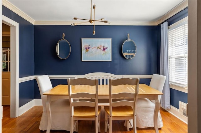 dining space featuring hardwood / wood-style flooring and ornamental molding