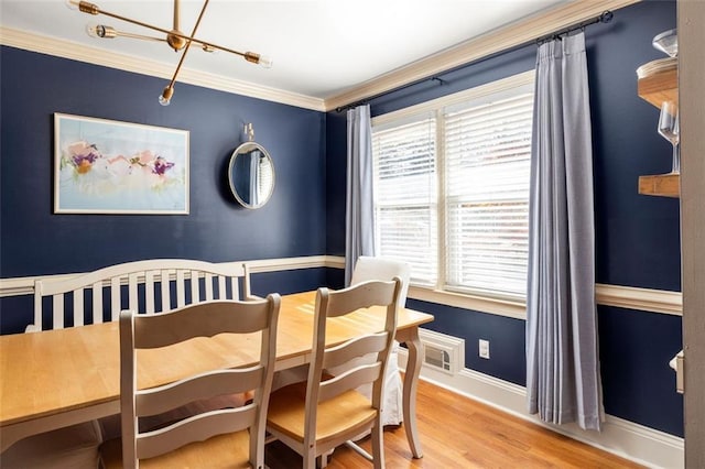 dining room with hardwood / wood-style flooring, crown molding, and a healthy amount of sunlight