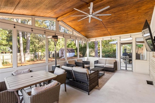 sunroom featuring a wealth of natural light, vaulted ceiling, ceiling fan, and wood ceiling