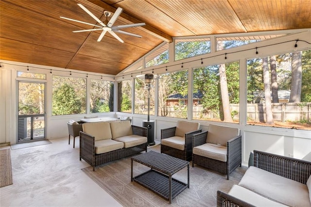 sunroom / solarium featuring a healthy amount of sunlight, lofted ceiling with beams, ceiling fan, and wooden ceiling