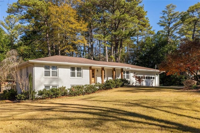 single story home with covered porch, a garage, and a front lawn