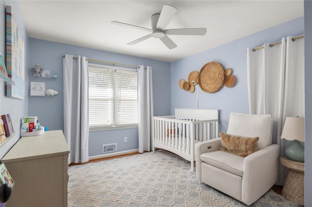 bedroom featuring a crib and ceiling fan