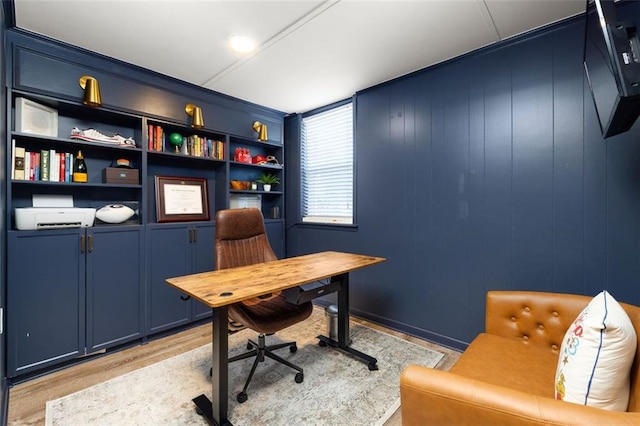 office with wooden walls, built in features, and light hardwood / wood-style flooring