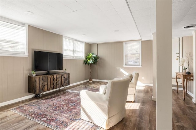 living room with wood-type flooring and wooden walls