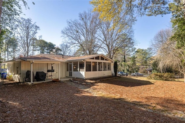 back of property with a sunroom