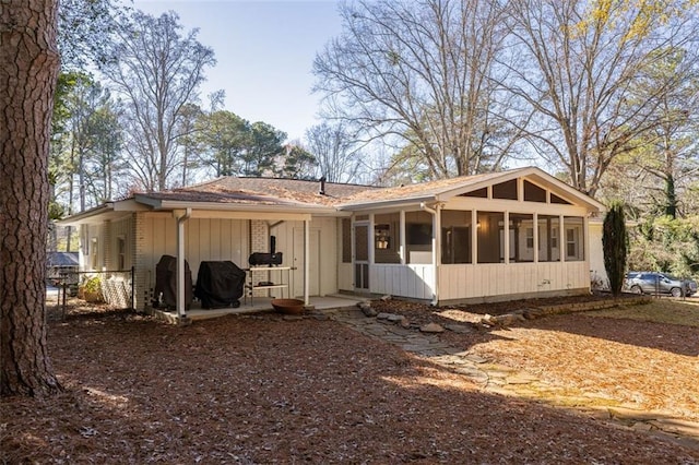 rear view of property featuring a sunroom