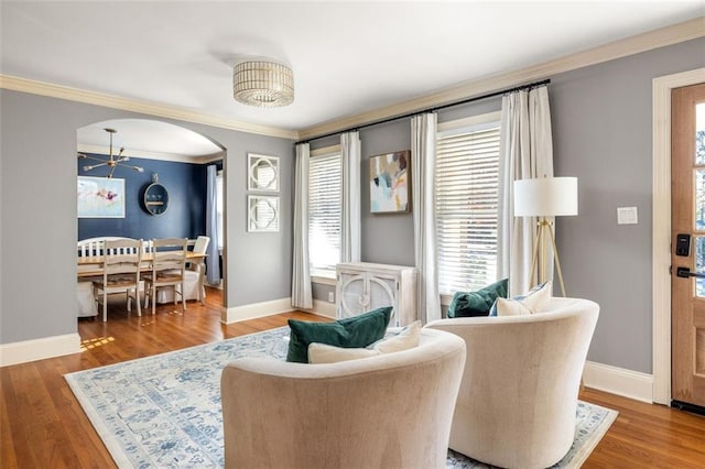 living area featuring a chandelier, hardwood / wood-style flooring, and ornamental molding