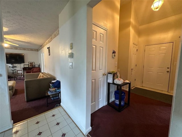 5546 Wellborn Creek Dr, Lithonia, GA 30058 - corridor with carpet flooring, a textured ceiling, tile patterned flooring, and baseboards
