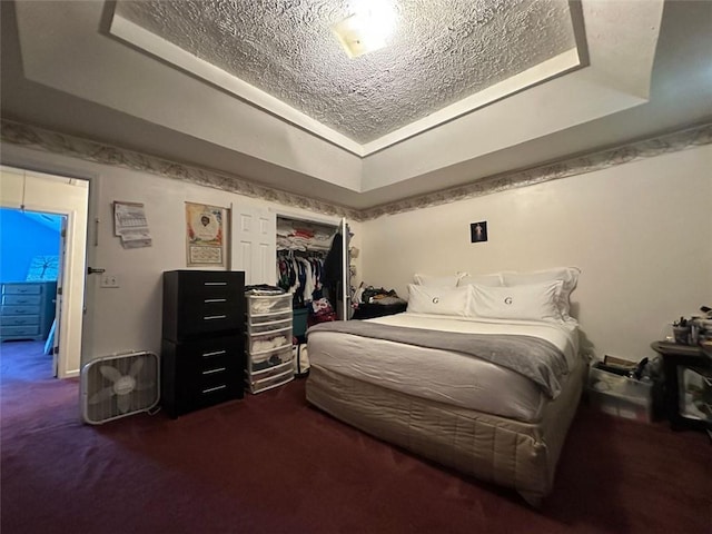 5546 Wellborn Creek Dr, Lithonia, GA 30058 - bedroom featuring a raised ceiling, dark carpet, a textured ceiling, and a closet
