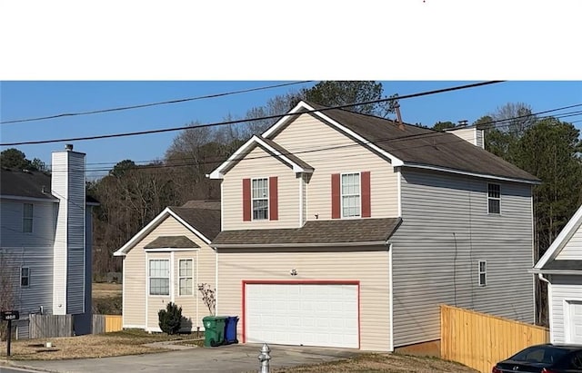 traditional-style house with driveway, a garage, fence, and roof with shingles